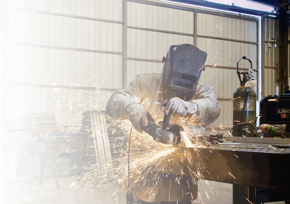 A person using an electric grinder to cut metal.