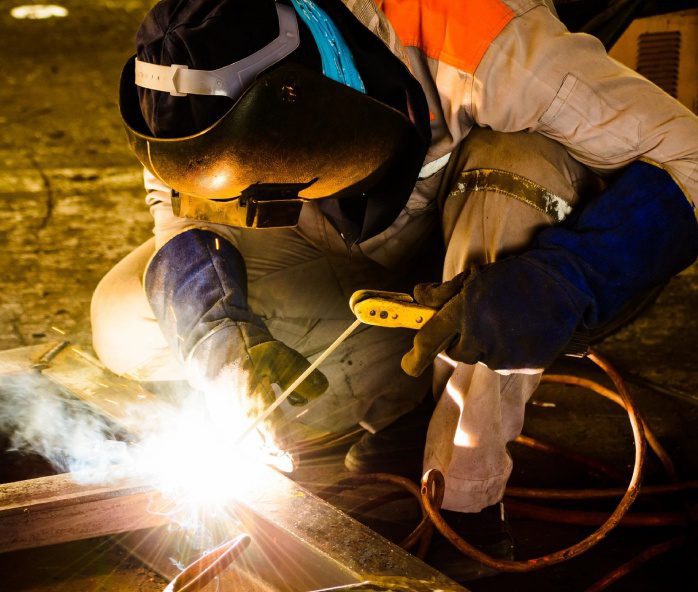 A man welding metal with an electric arc.