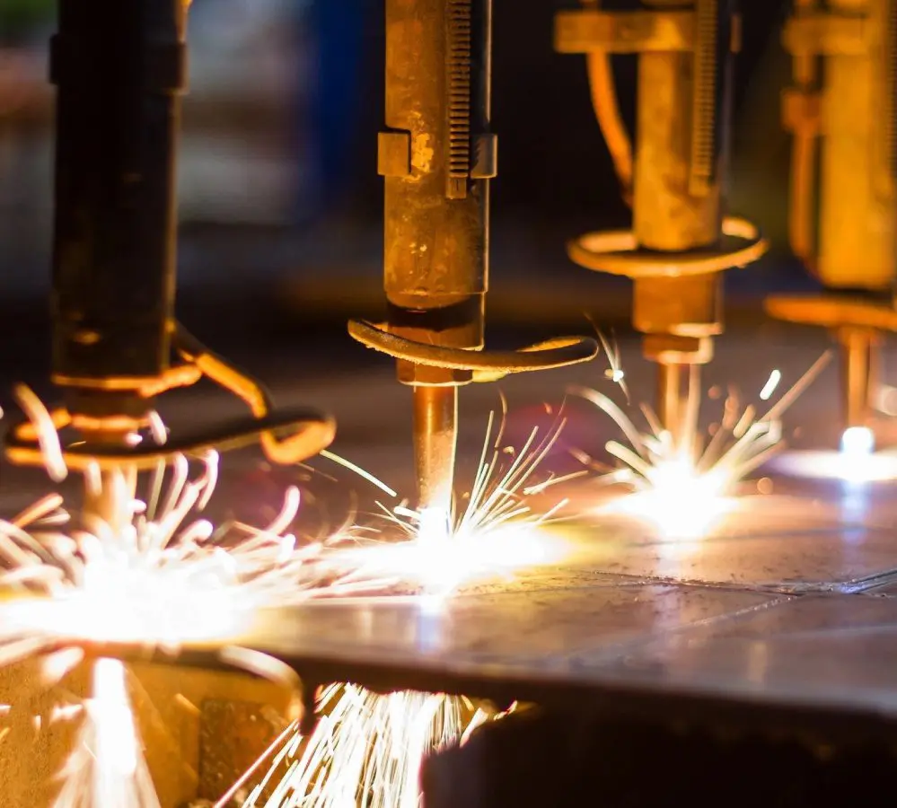 A group of people welding metal with bright sparks.